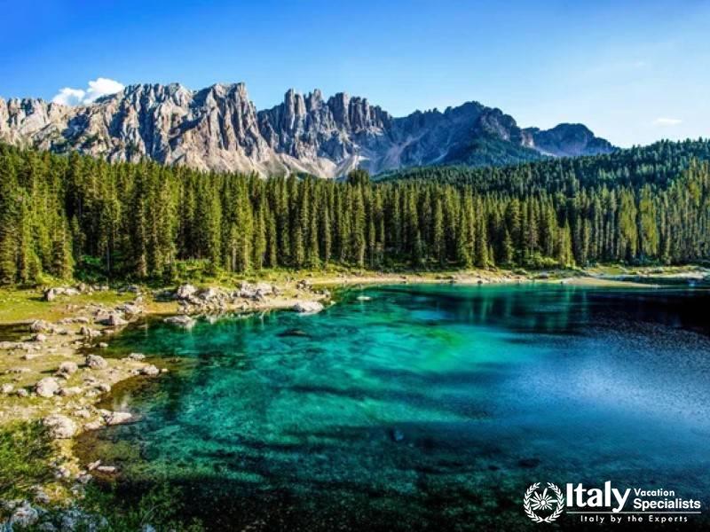 The vibrant emerald waters of Lake Carezza reflecting the majestic Latemar mountains.