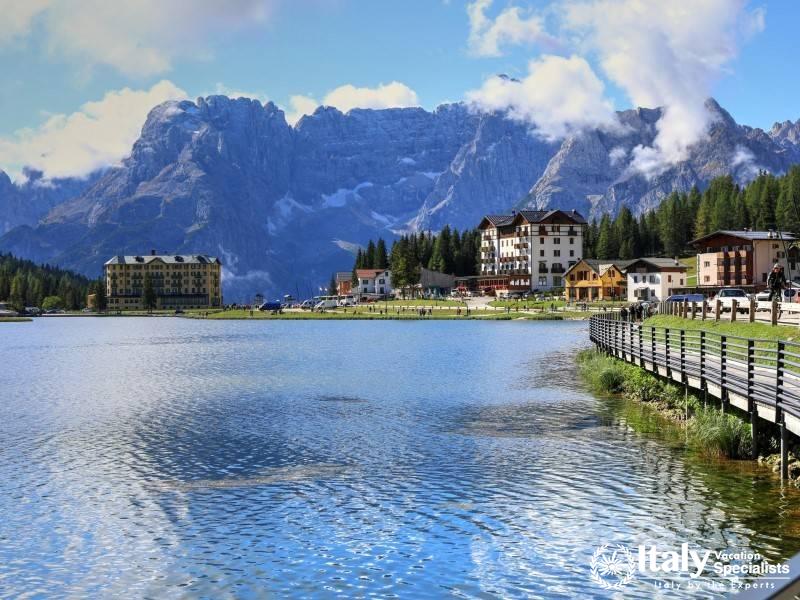 A picturesque lakeside view of Lake Misurina, with charming buildings and majestic peaks in the back