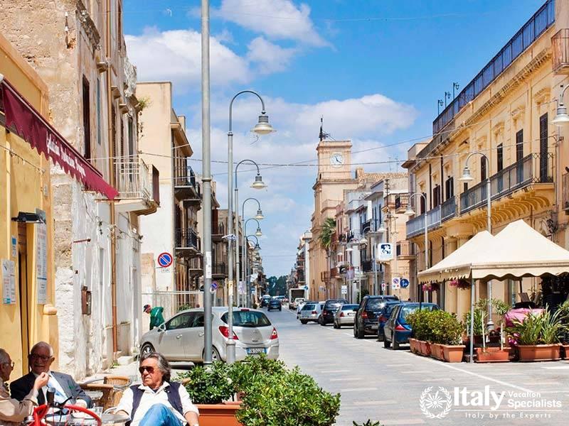 Picturesque panorama of a village on the slopes of Mount Etna, with the volcanos peak in the distan