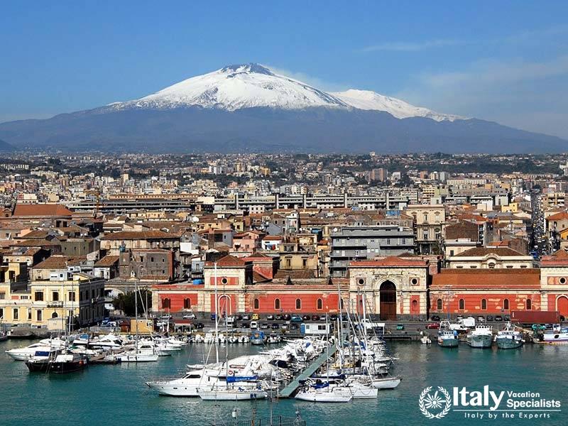 Picturesque scene of a small town on the slopes of Mount Etna, with the volcano towering in the back