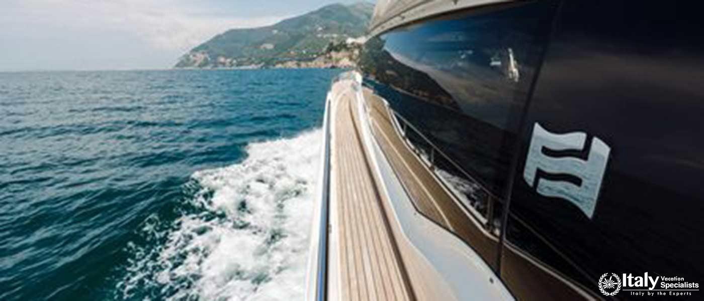 An image depicting a luxury yacht cruising along the coast, with a clear view of the rugged shorelin
