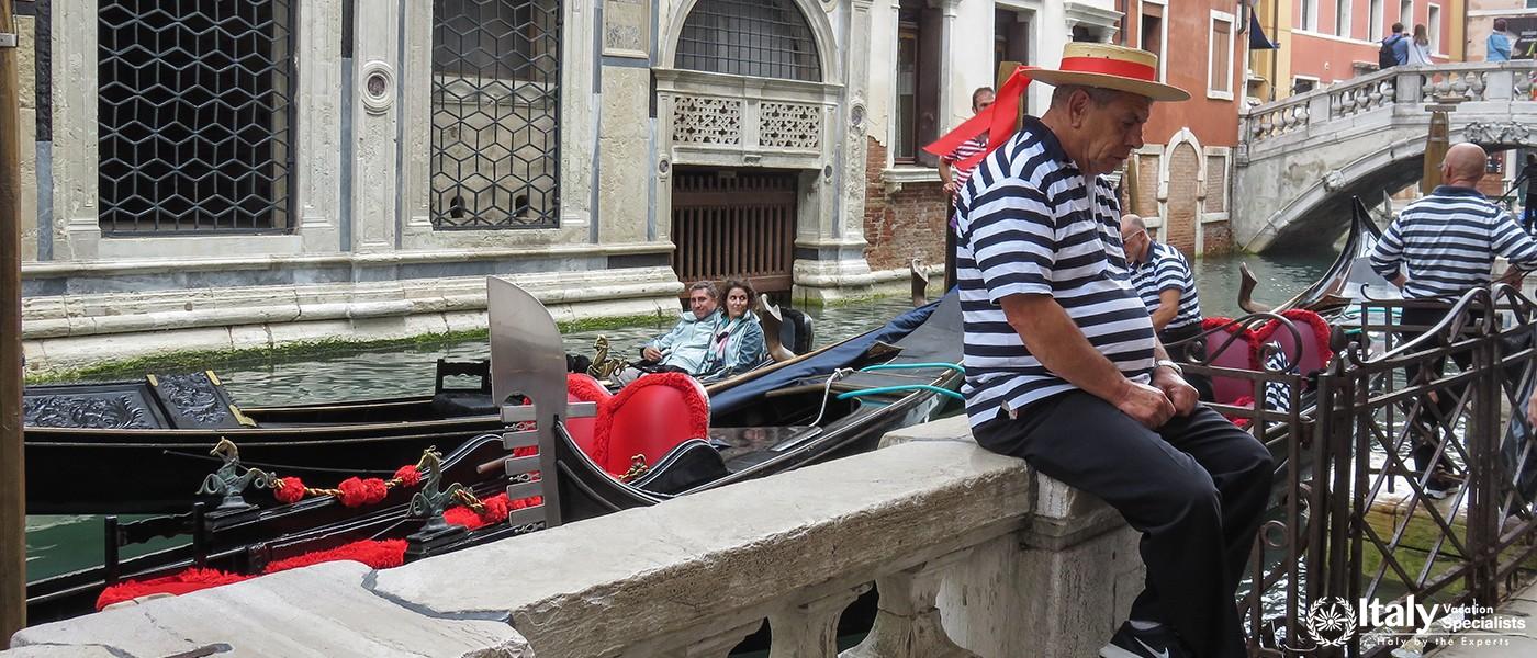 ITALY, VENICE - OCTOBER 15, 2014Typical Venetian gondolier in traditional clothing is waiting for cu