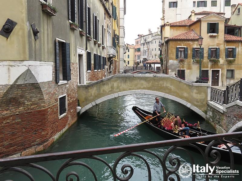 VENICE, ITALY - OCTOBER 15, 2014 Boats on a small canal with bridges in the heart of Venice.