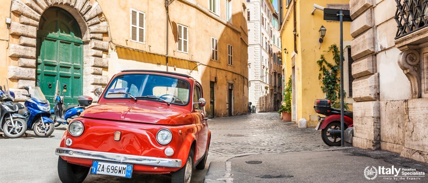Rome, Italy - May 2, 2016. Red vintage Fiat Nuova 500 parked in the old street in Rome