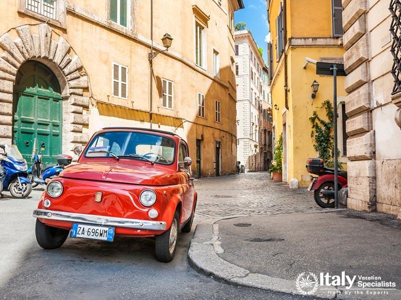 Rome, Italy - May 2, 2016. Red vintage Fiat Nuova 500 parked in the old street in Rome