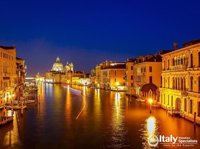 Venice night cityscape at grand canal with buildings and famous church, long exposure