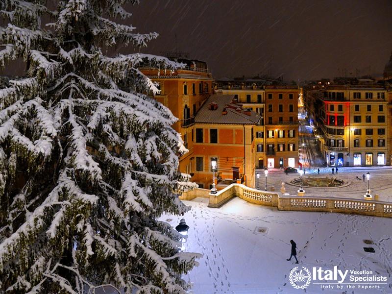 Night snowfall on Spanish square and steps in Rome with lonely person, old buildings and architectur